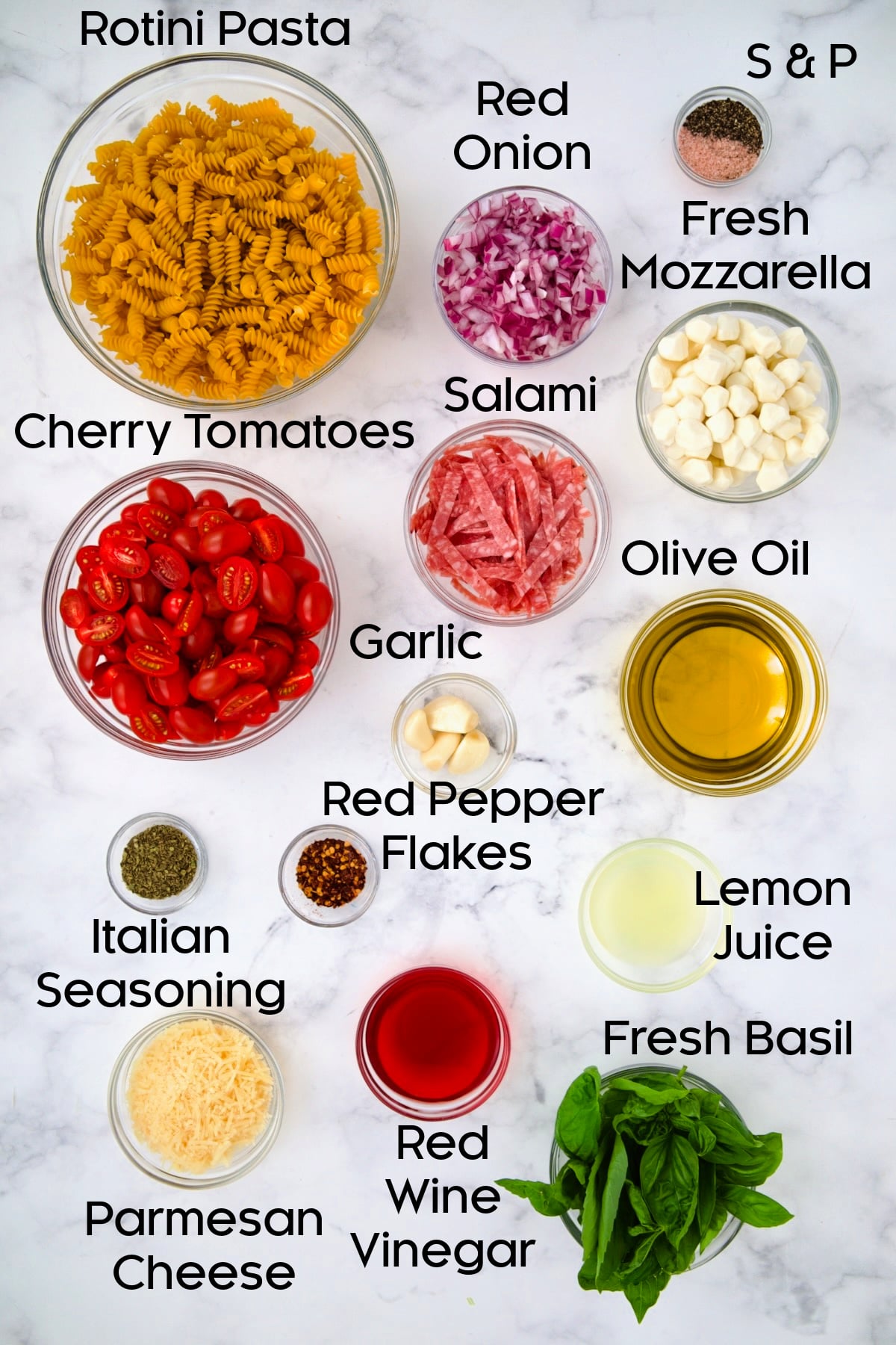 Ingredients for Caprese Pasta Salad in glass bowls.