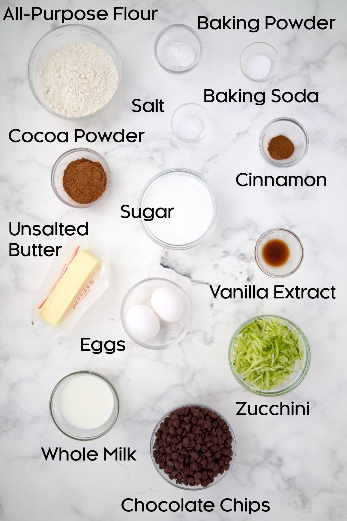 Ingredients for Chocolate and Zucchini Muffins in glass bowls.