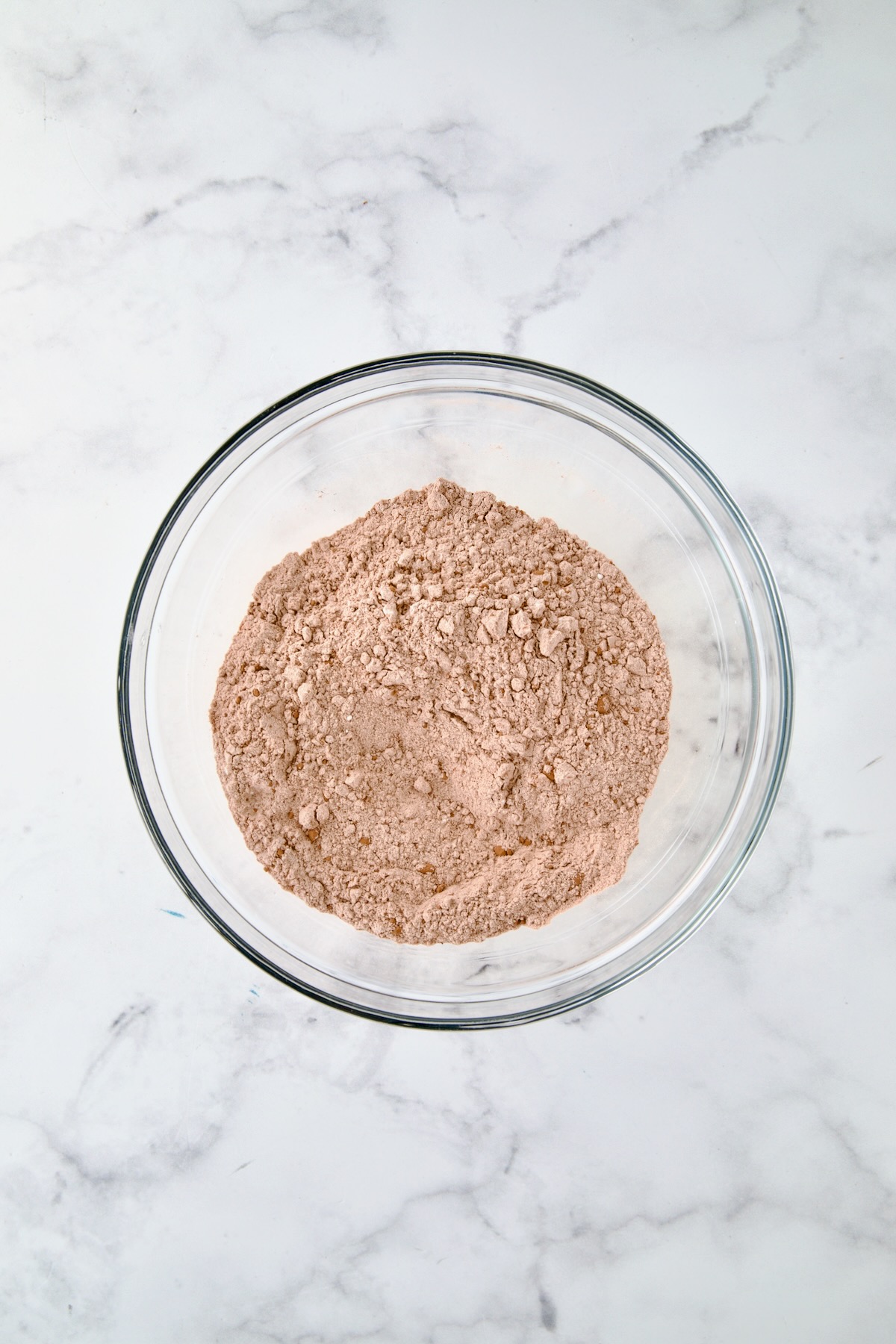 Dry ingredients for muffins in glass bowl.
