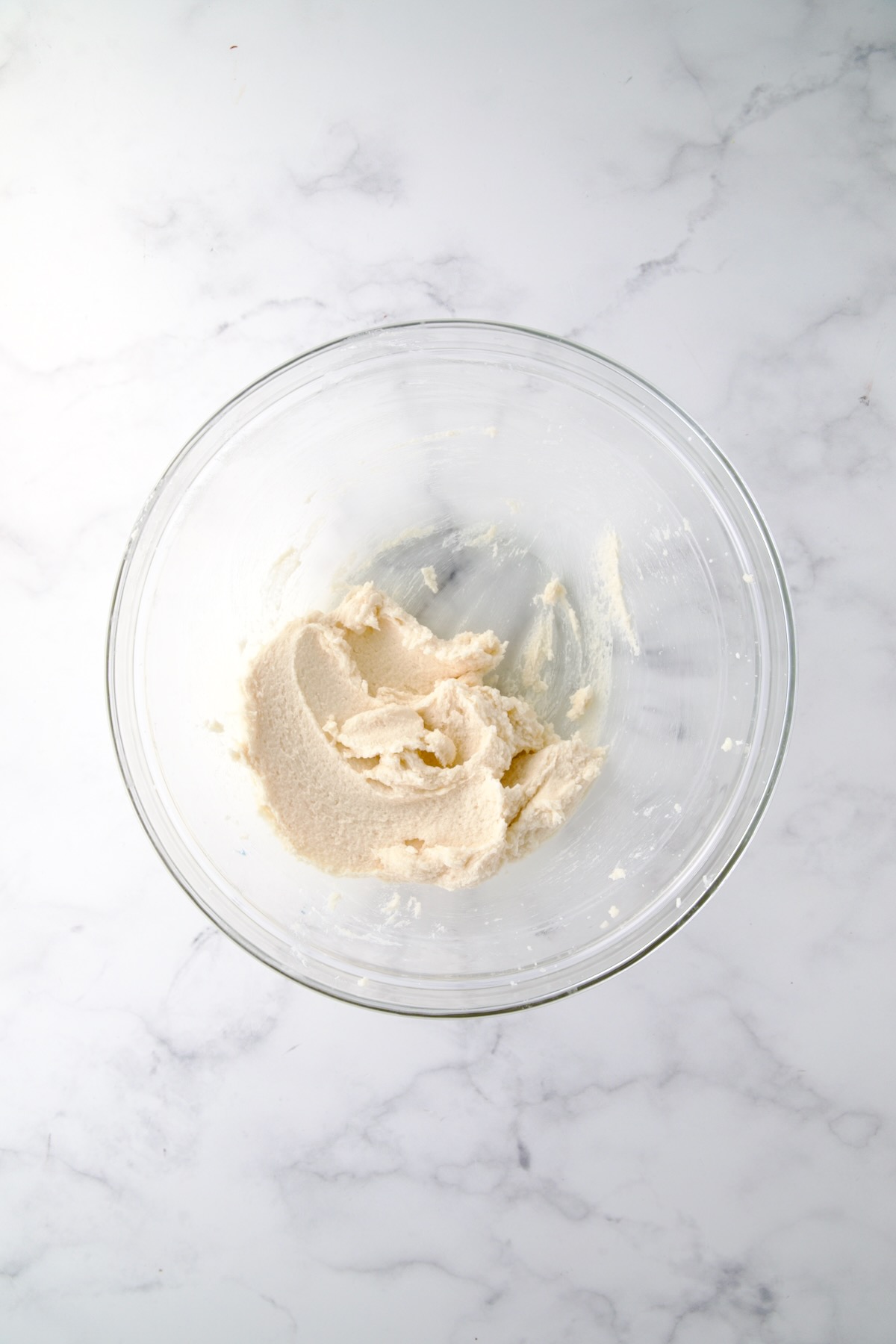 Creamed butter and sugar in glass bowl.