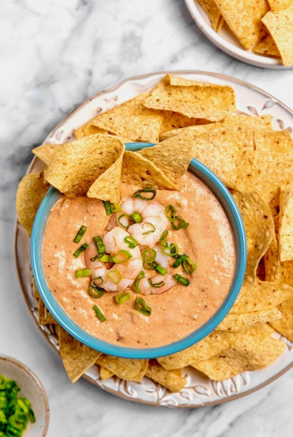 Creamy Shrimp Salsa Dip in bright blue bowl on platter with tortilla chips.
