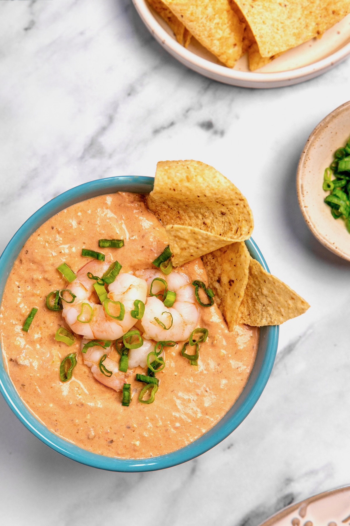 Creamy Shrimp Salsa Dip in bright blue bowl with tortilla chips.