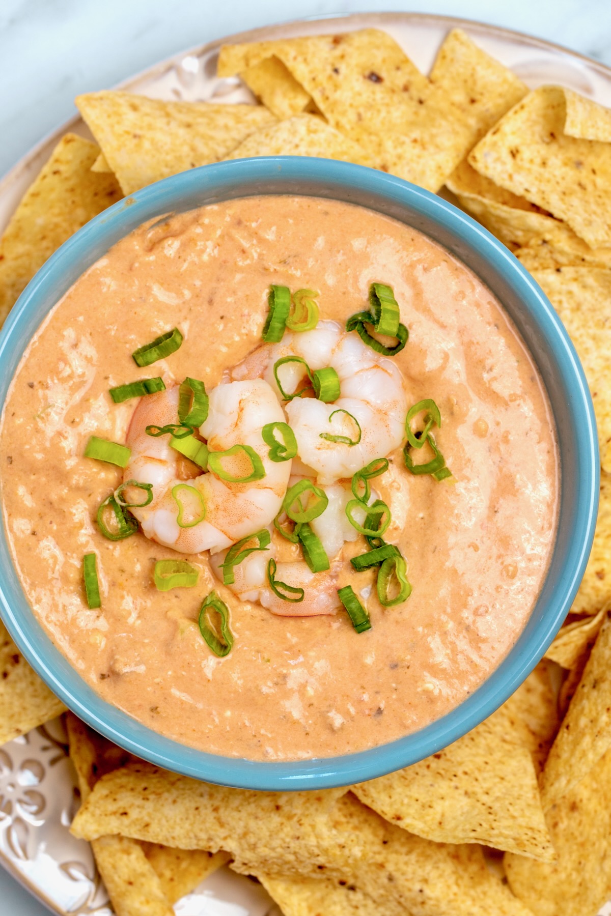 Creamy Shrimp Salsa Dip in bright blue bowl with tortilla chips.