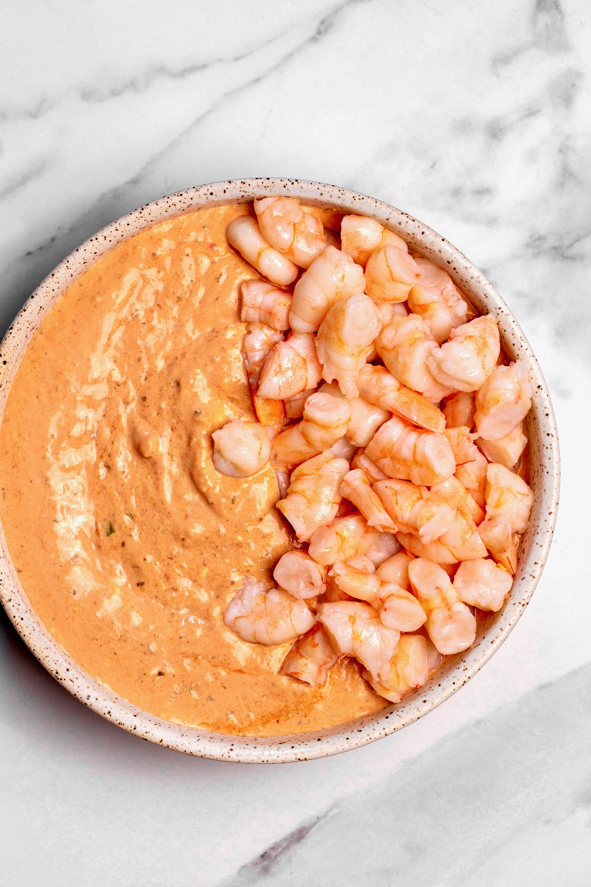 Shrimp dip with shrimp on half.