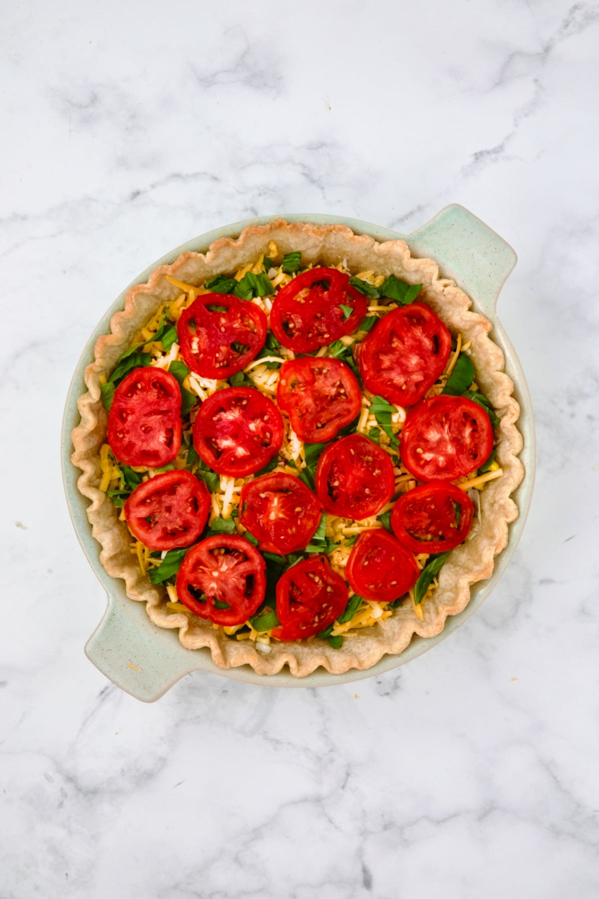 Fully assembled and layered tomato pie before custard is poured in.
