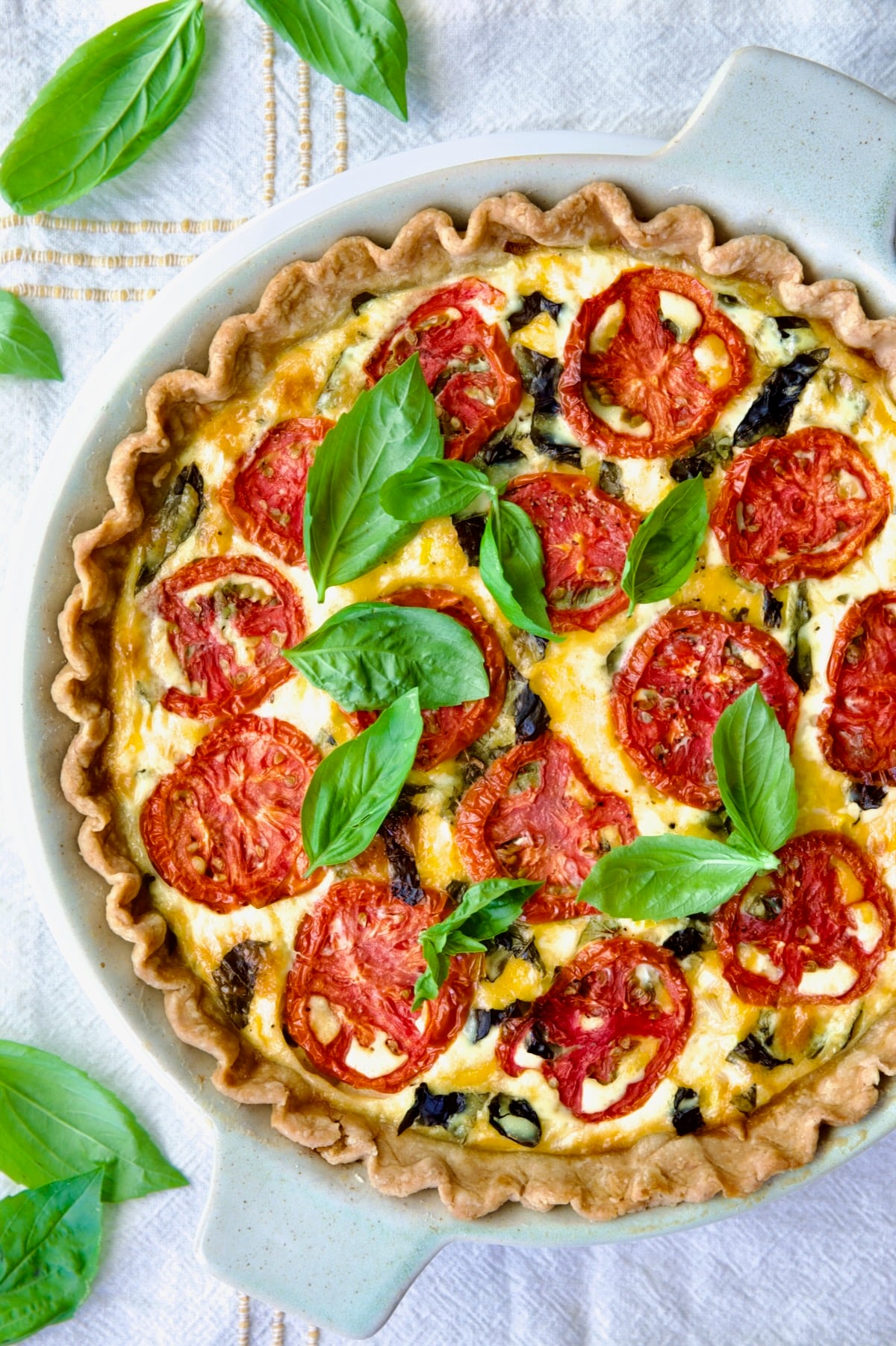 Fully baked Tomato Pie Recipe with Corn and Basil with fresh basil leaves on top.