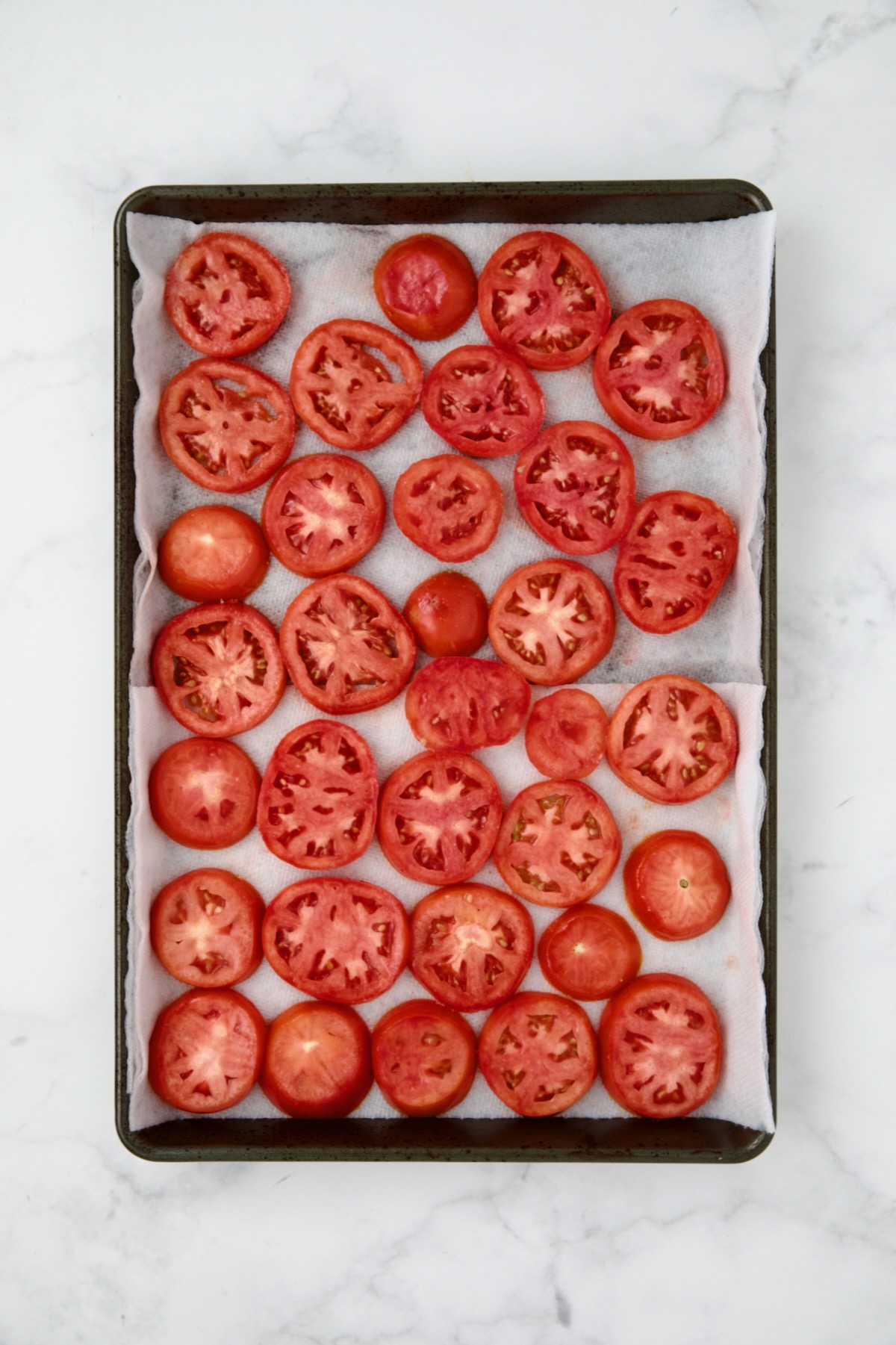 Tomato slices on paper towel-lined rimmed baking sheet.