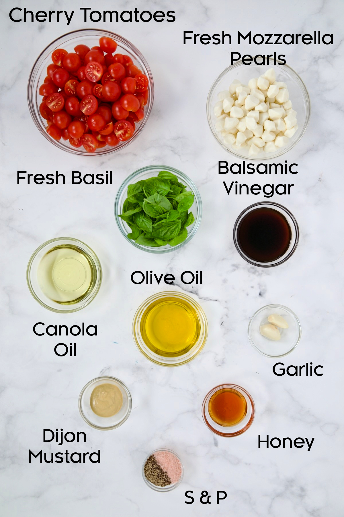 Ingredients for Caprese Salad with Cherry Tomatoes in glass bowls.