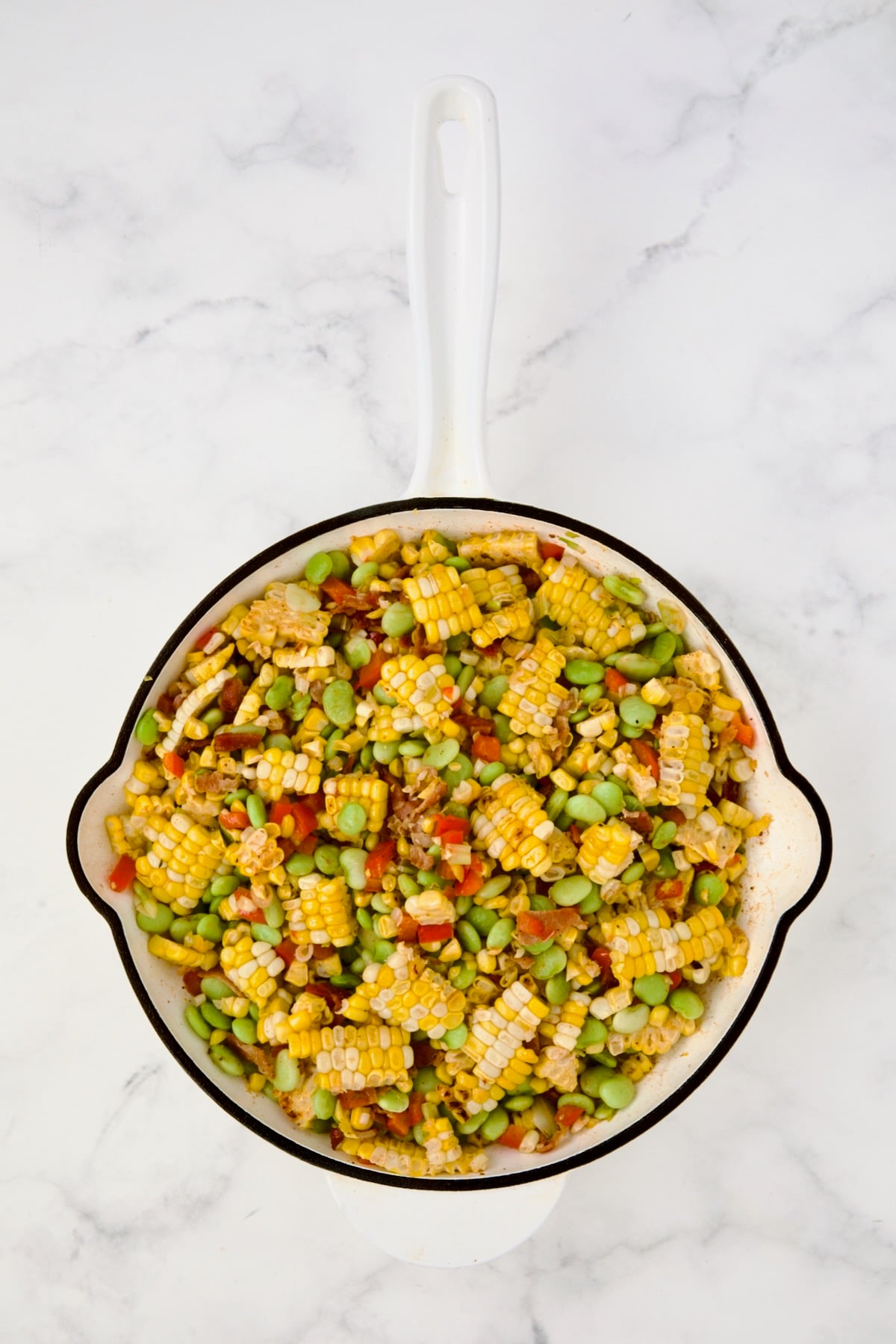 Succotash in white enamel cast iron skillet.
