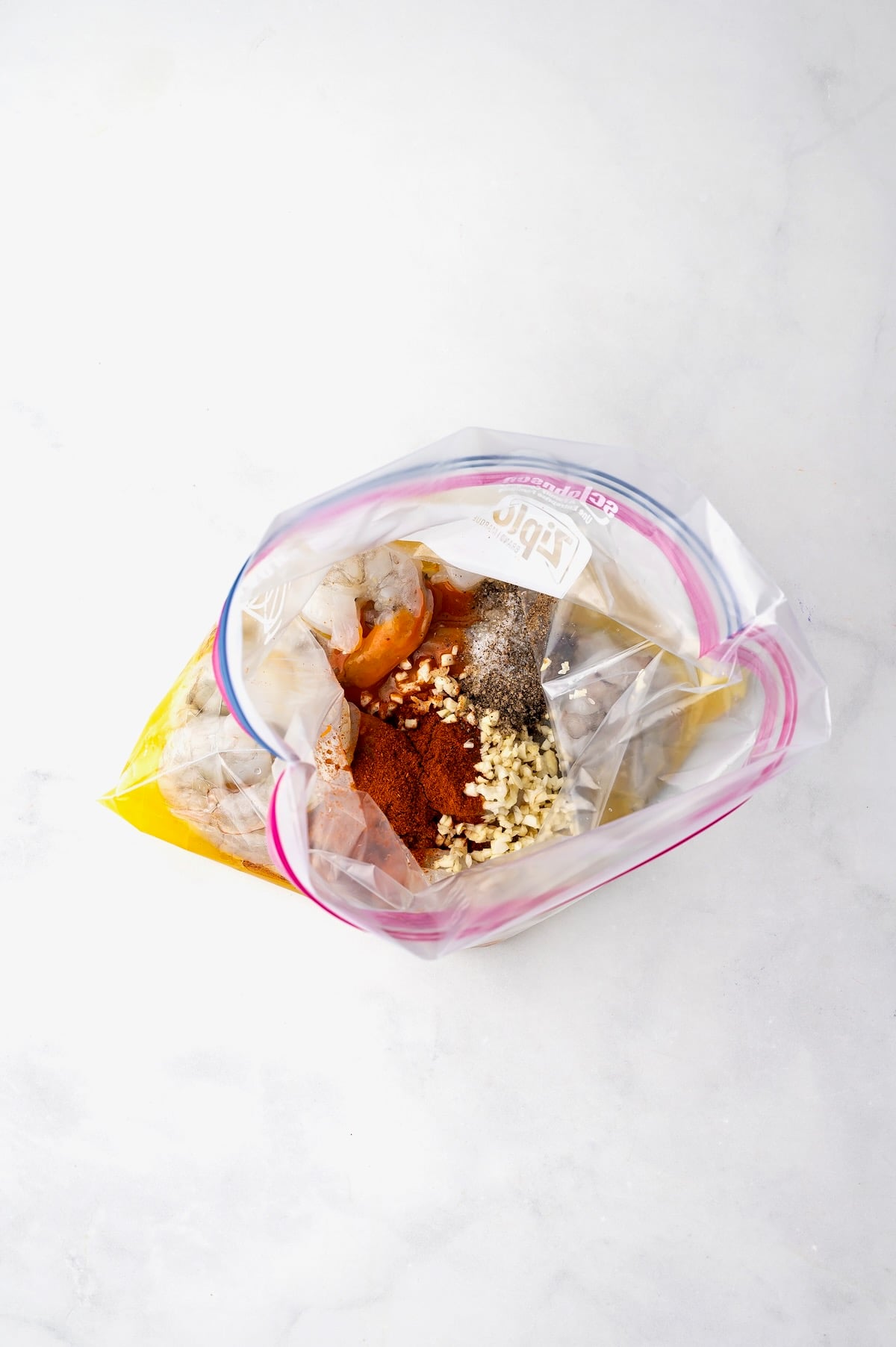 Shrimp in marinade in zipper top bag.