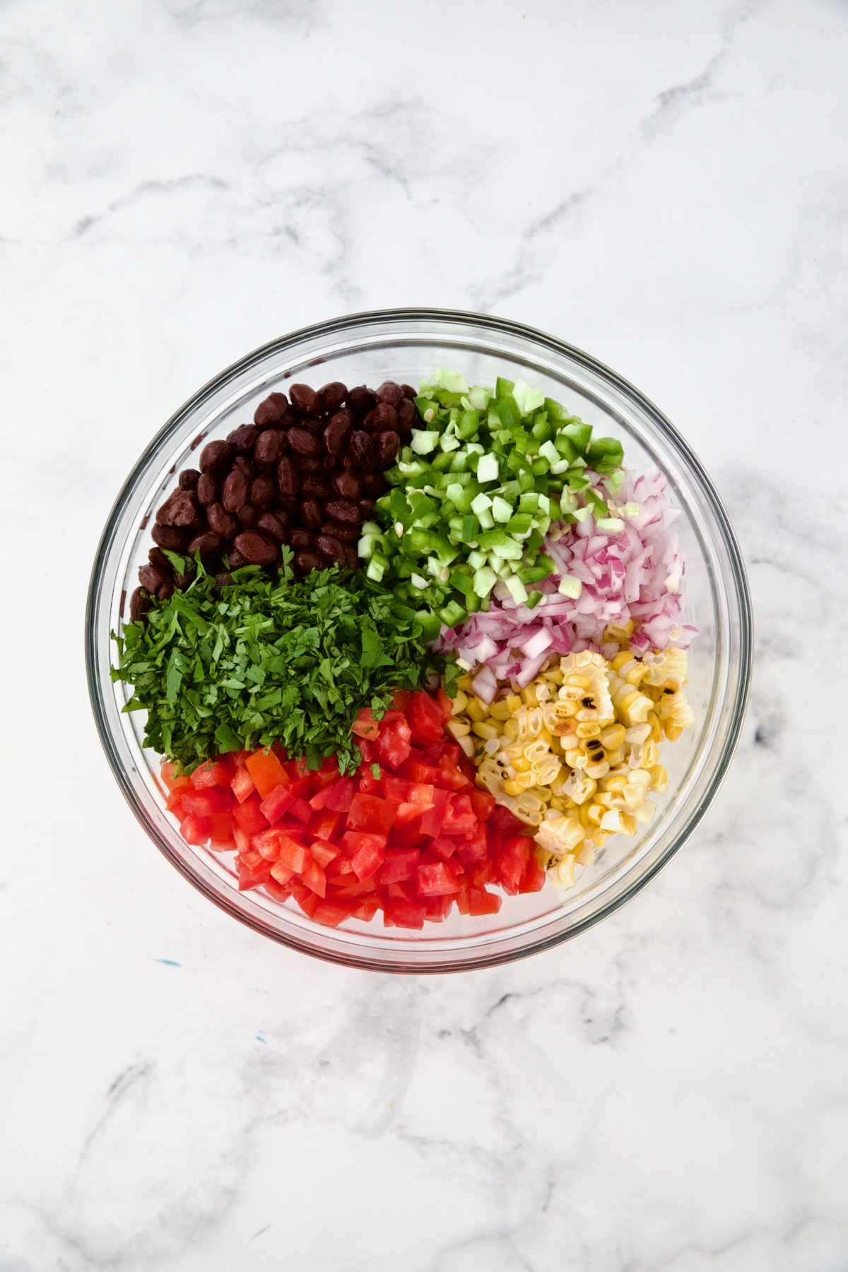 Ingredients for Black Bean Corn Tomato Salad in glass bowl before being combined.