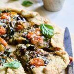 Two wedges of Mediterranean Vegetable Galette on parchment paper.