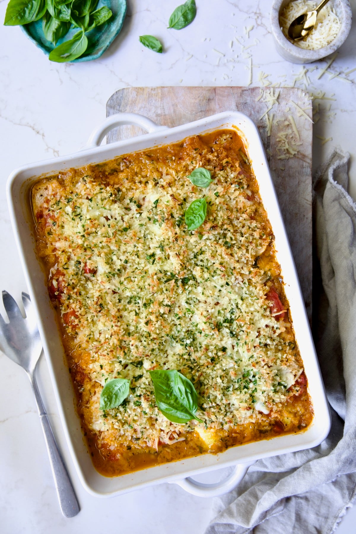 Summer Vegetable Parmigiana in white rectangular baking dish garnished with fresh basil.