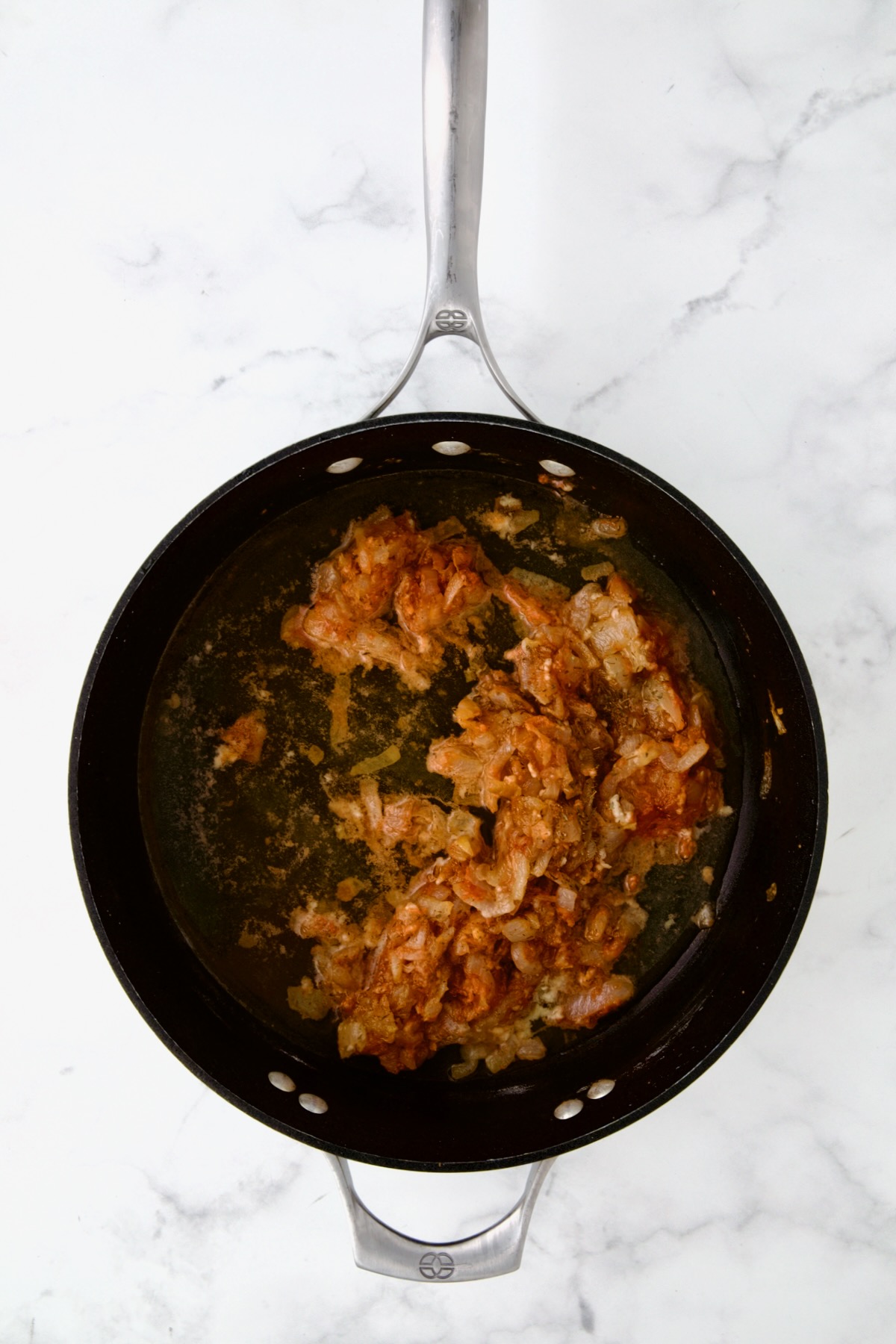 Onions and tomato paste in nonstick skillet.