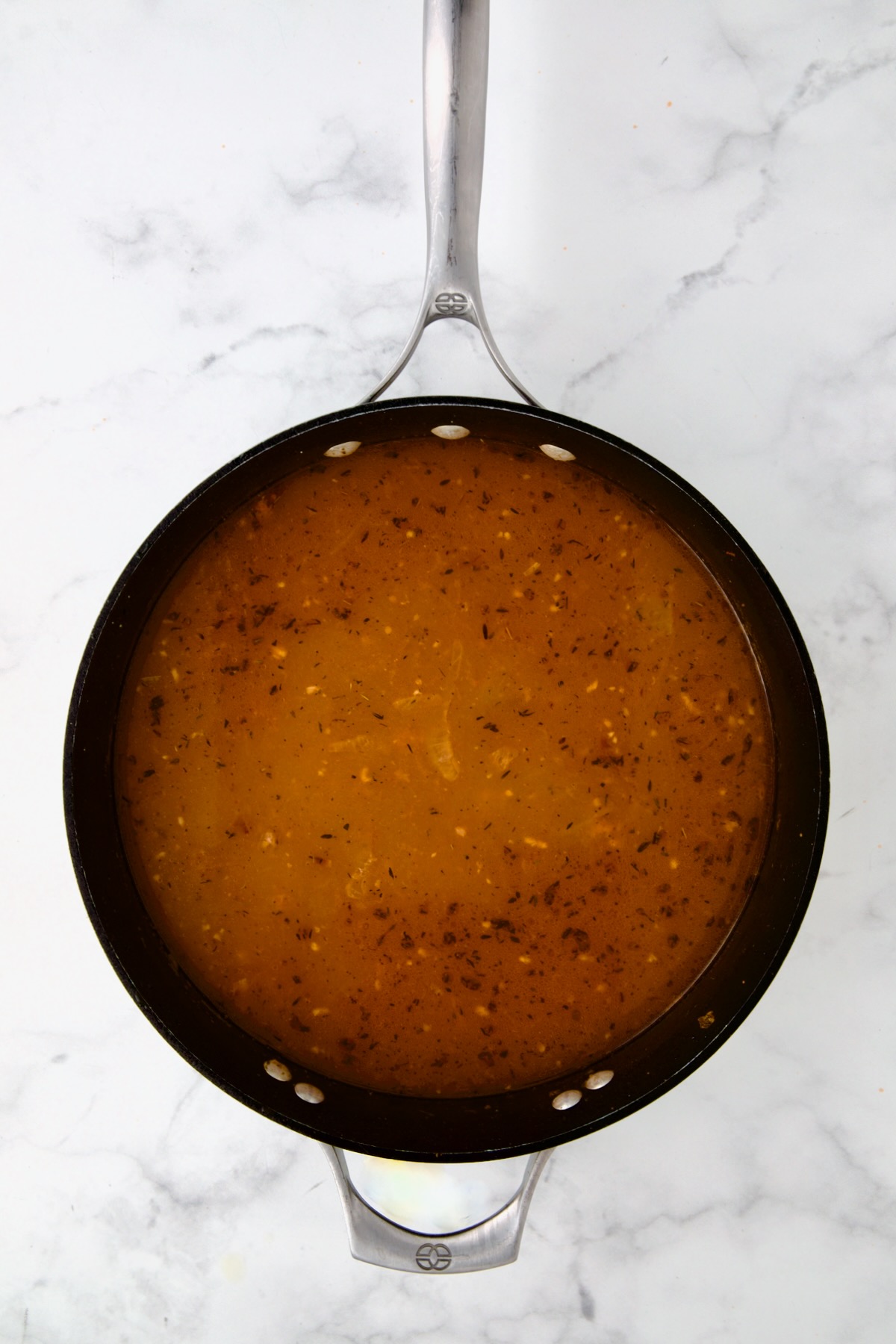 Beer added to onions, tomato paste and flour in nonstick skillet.
