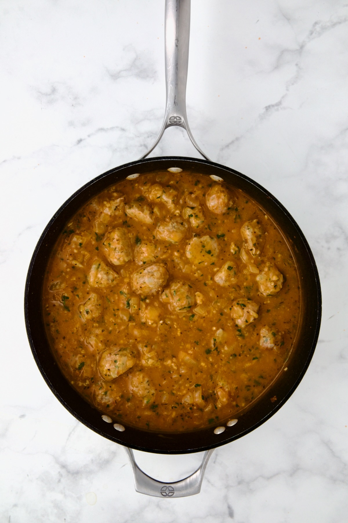 Meatballs added back to sauce in nonstick skillet.