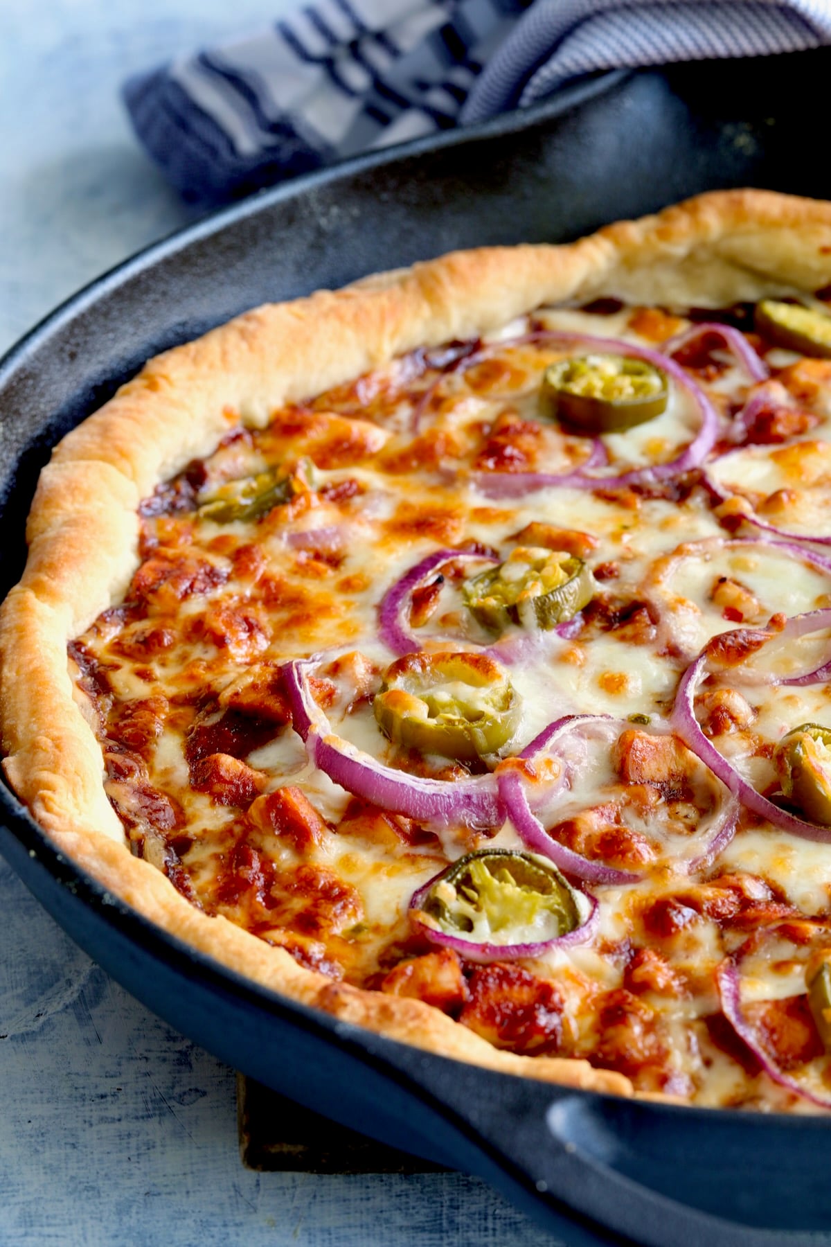 Topped pizza in cast iron skillet after being baked.