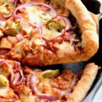 Piece of Cast Iron Skillet Pizza being lifted out of cast iron pan.