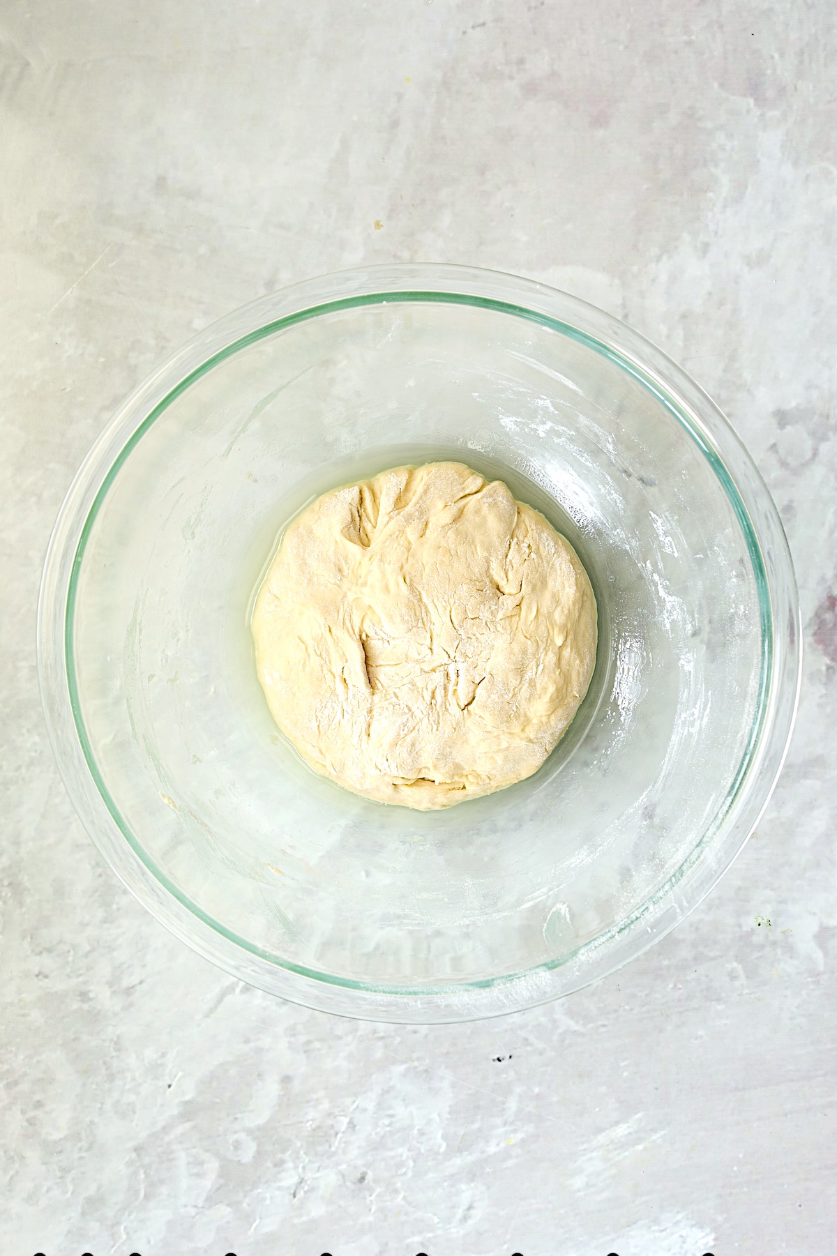 Pizza dough in glass bowl before rising.