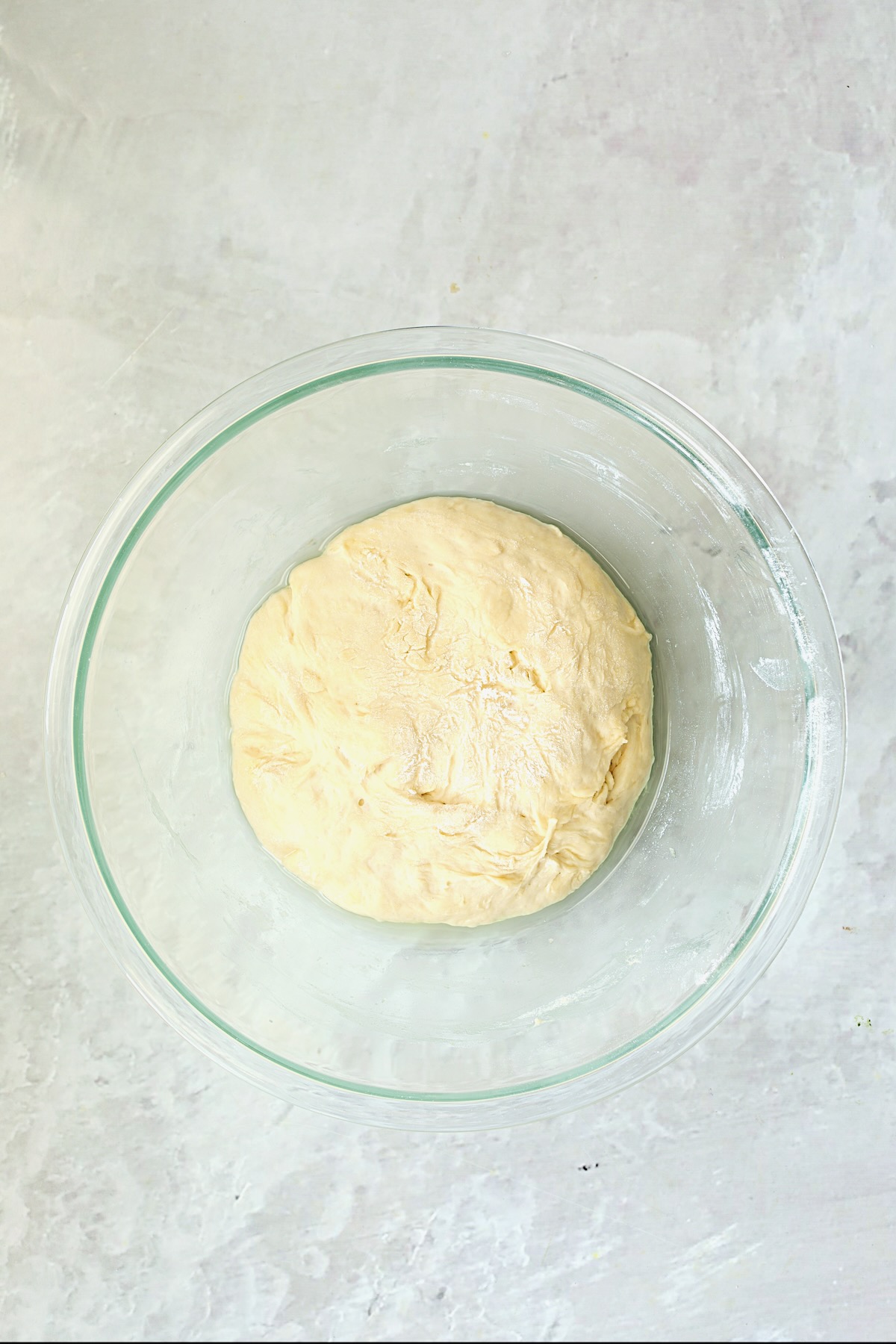 Pizza dough in glass bowl after rising.