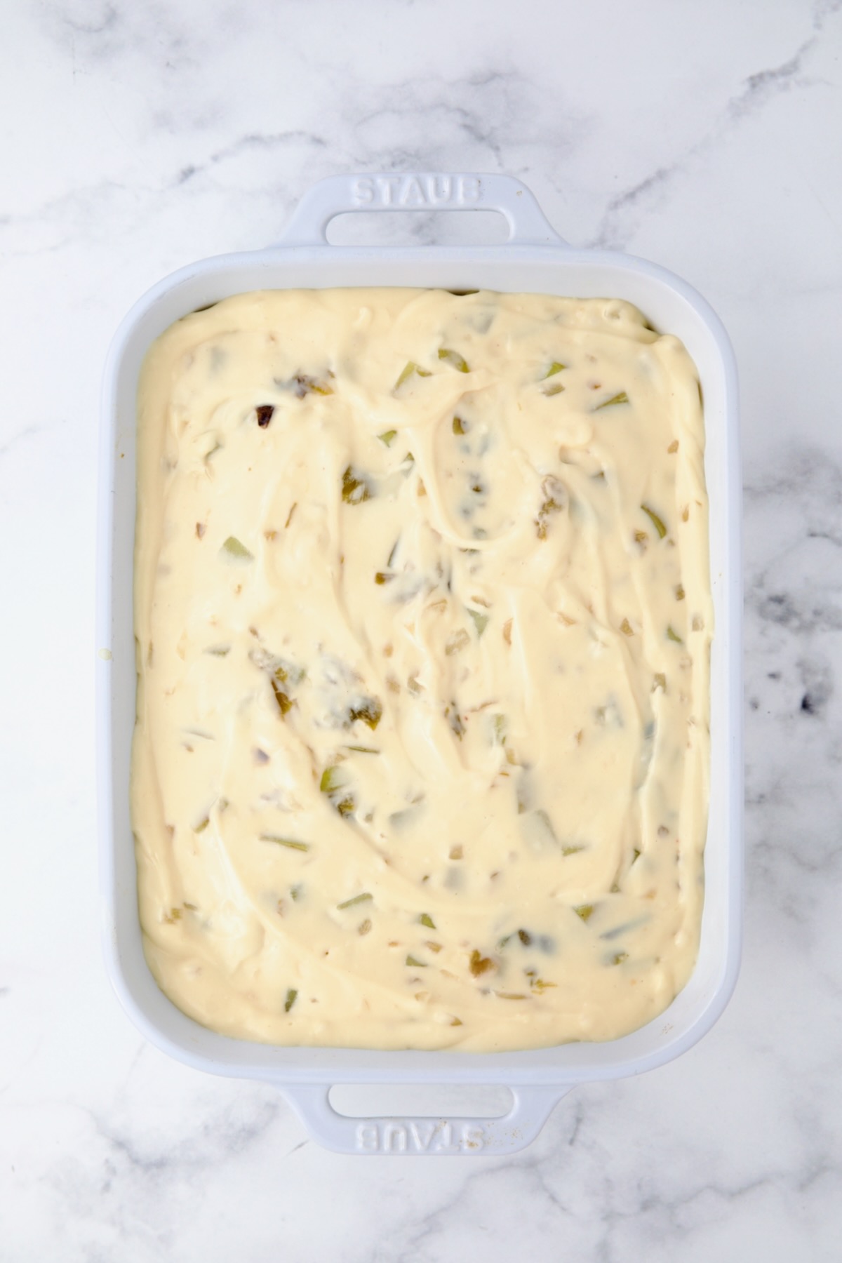 Assembled Hatch Green Chile au Gratin Potatoes in white rectangular baking dish before being baked.