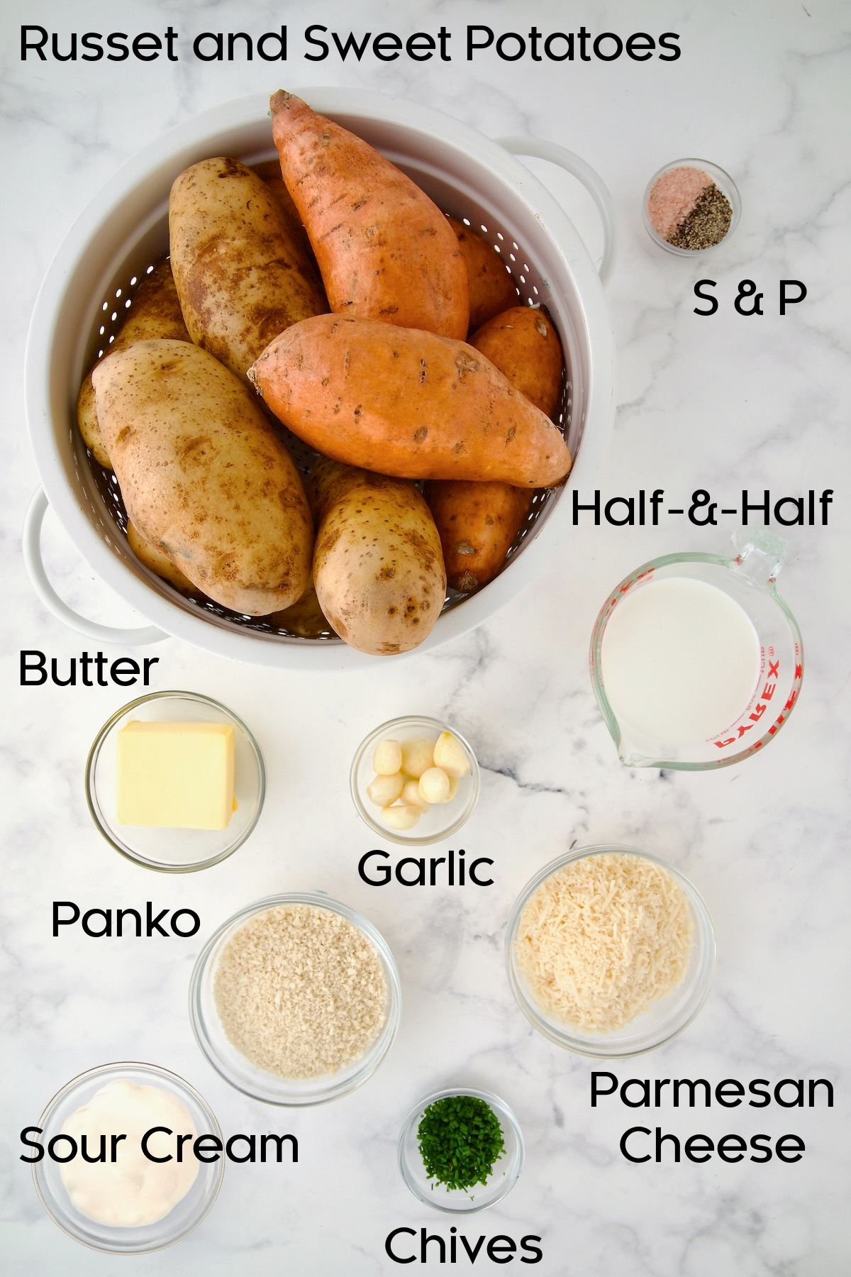 Ingredients for Potato and Sweet Potato Bake in glass bowls with potatoes in a white colander.