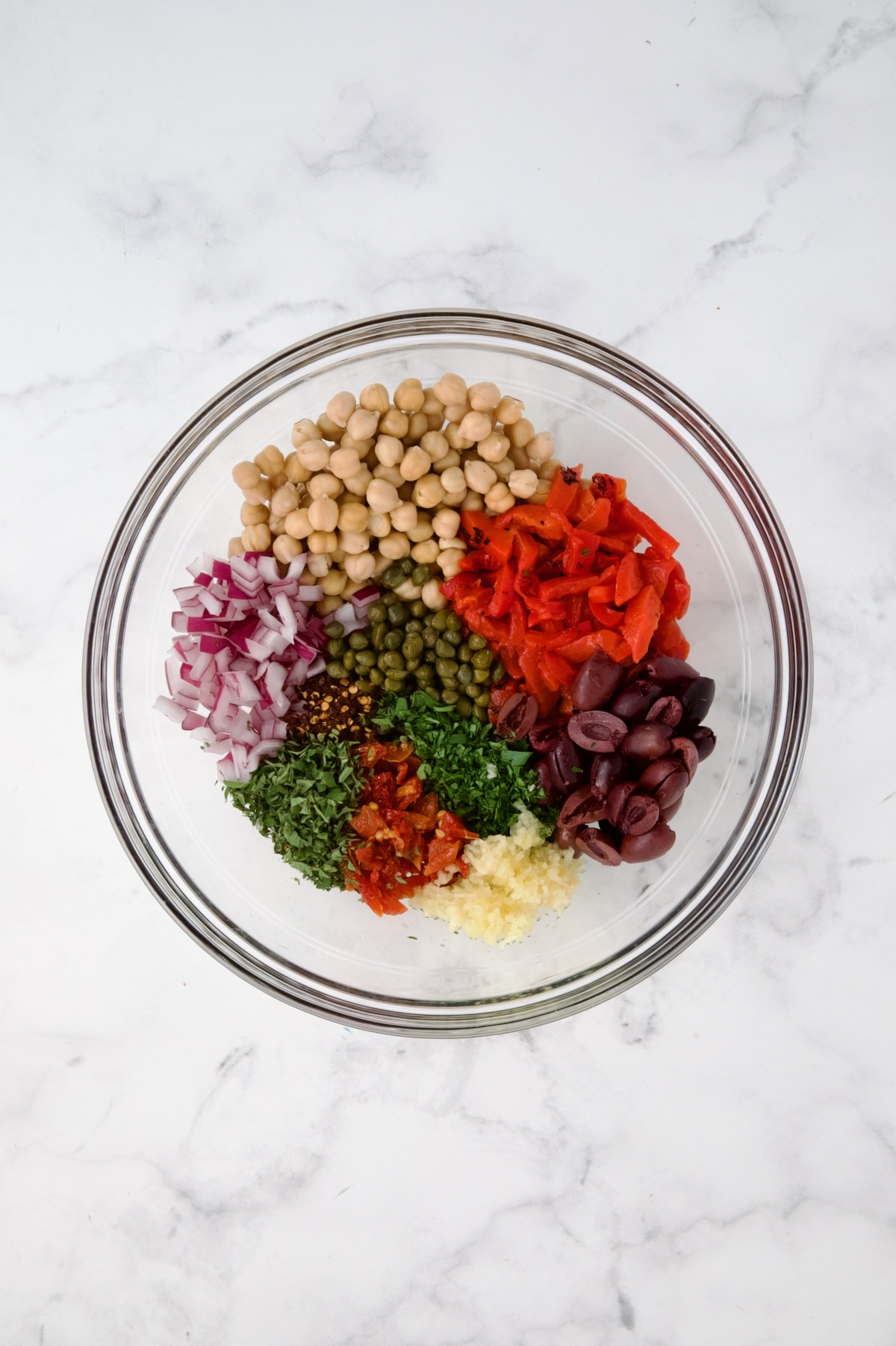 Ingredients for cauliflower salad in glass bowl before being combined.