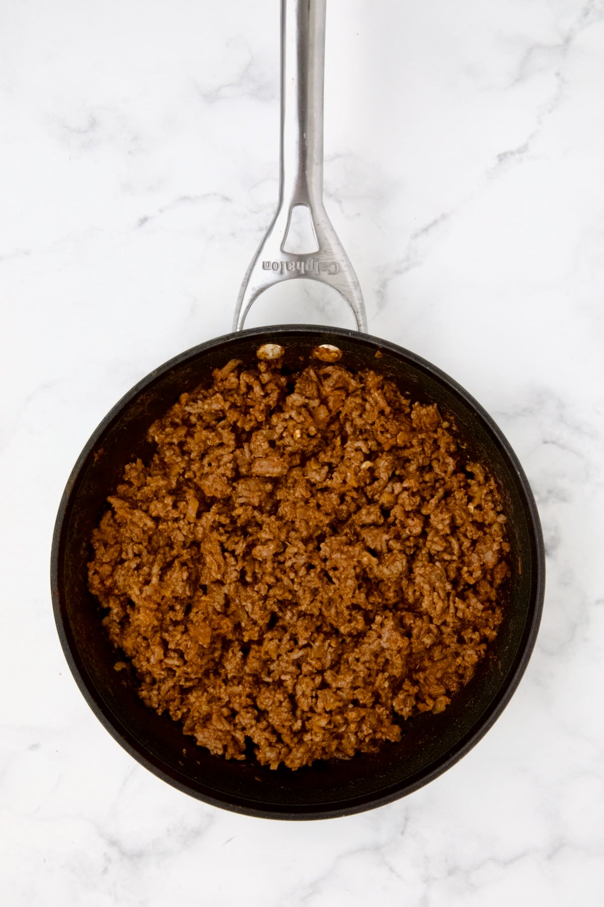 Cooked ground beef in nonstick skillet with taco seasoning and garlic cooked in.