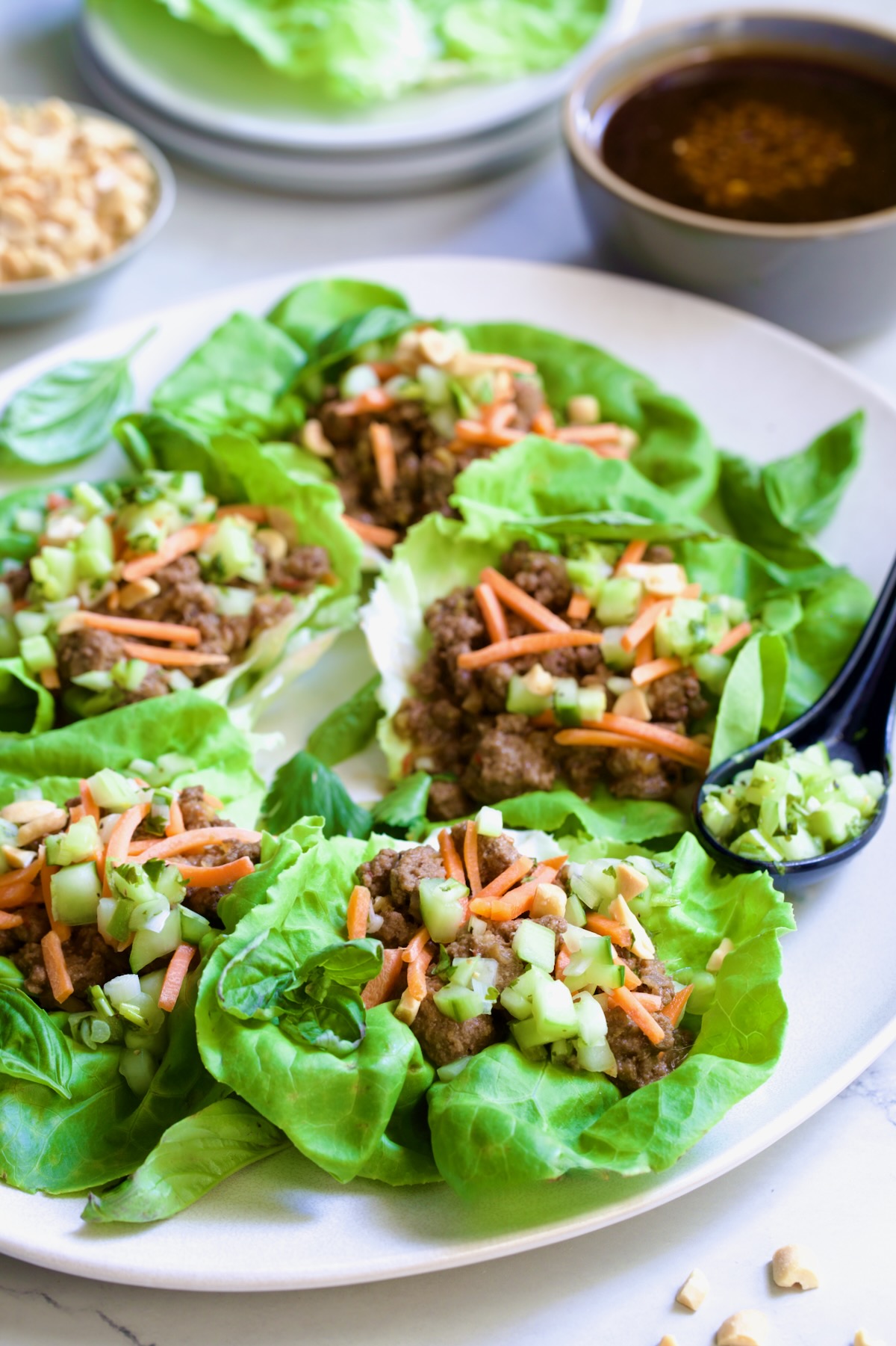 Six Vietnamese Beef Lettuce Wraps on white oval platter.