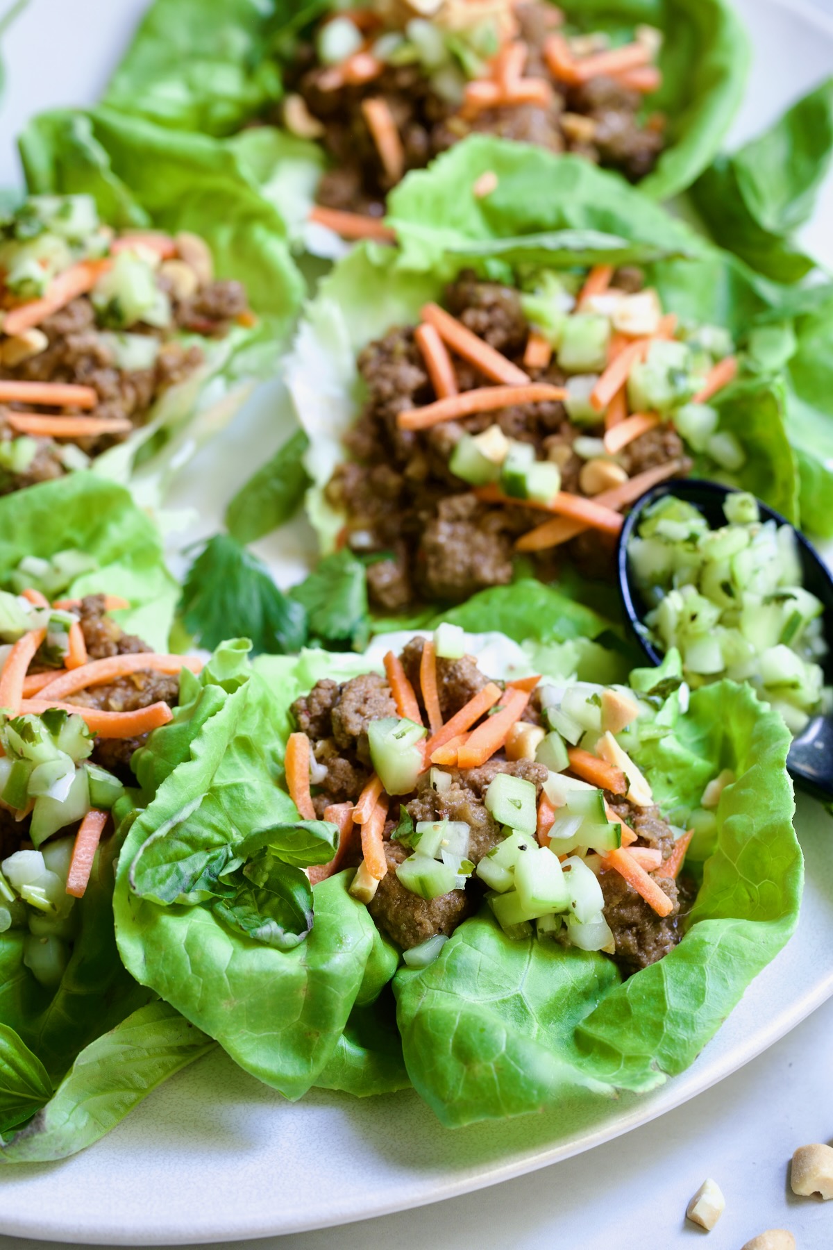 Six Vietnamese Beef Lettuce Wraps on white oval platter.