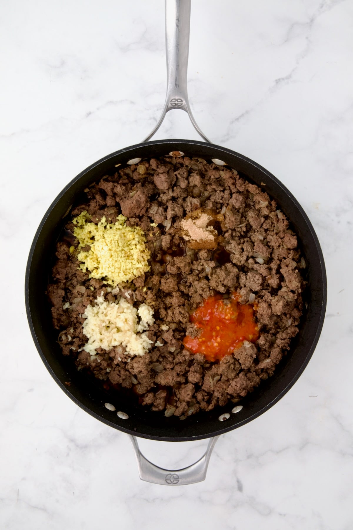 Cooked ground beef in nonstick skillet with ginger, garlic, chili sauce, soy sauce, brown sugar and chicken broth.
