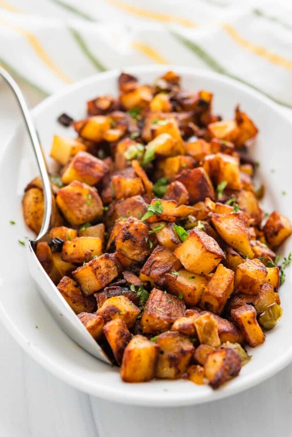 Breakfast potatoes in white oval bowl.