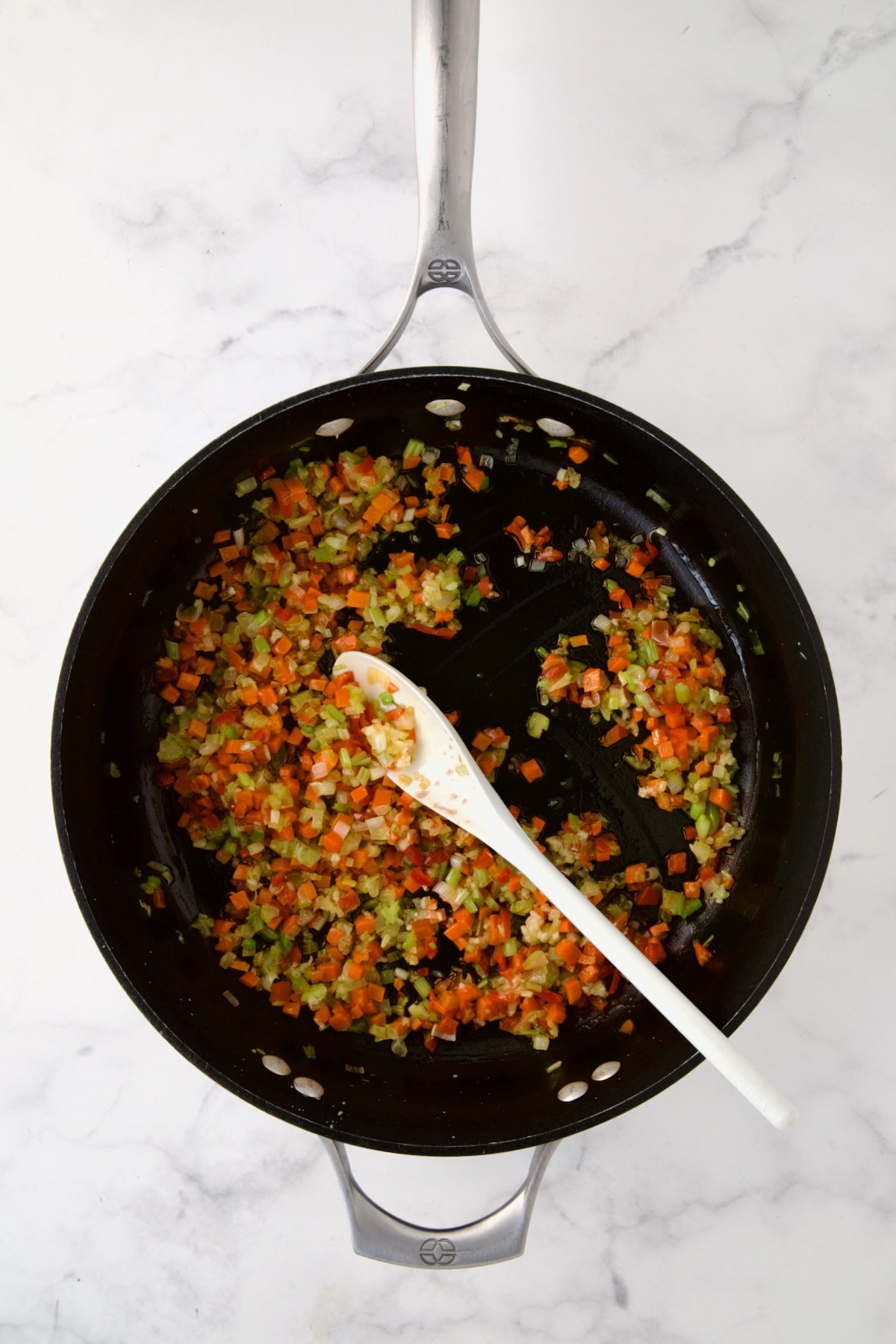 Cooked celery, carrots, red bell pepper and scallion in nonstick skillet.