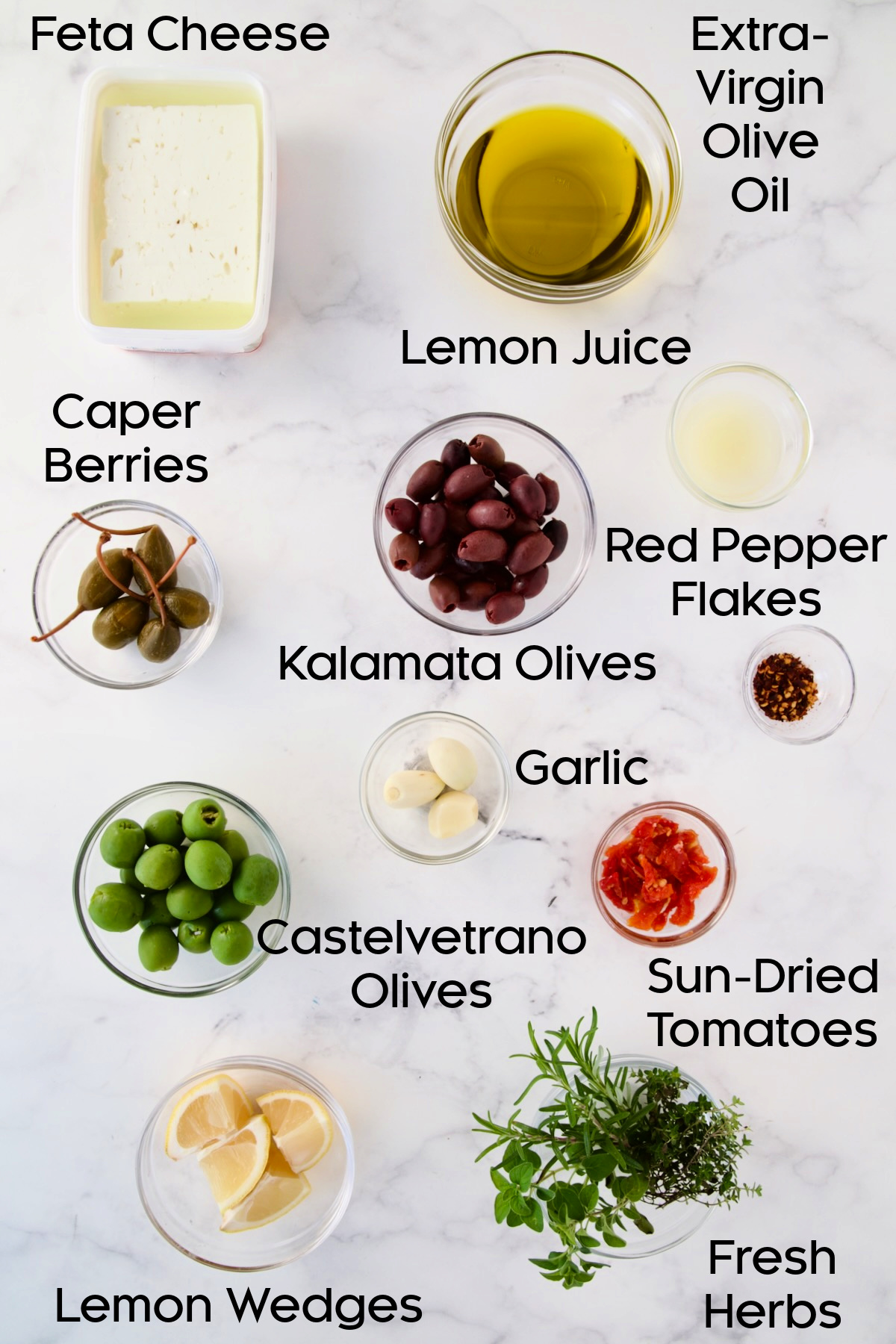 Ingredients for Baked Feta Cheese and Olives in glass bowls.