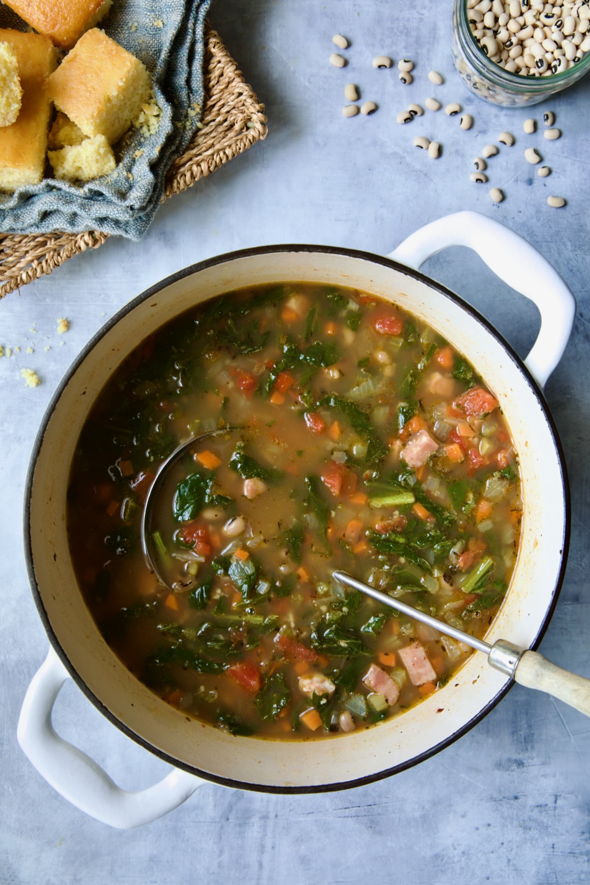 Black-Eyed Pea Soup in white Dutch oven with soup ladle.