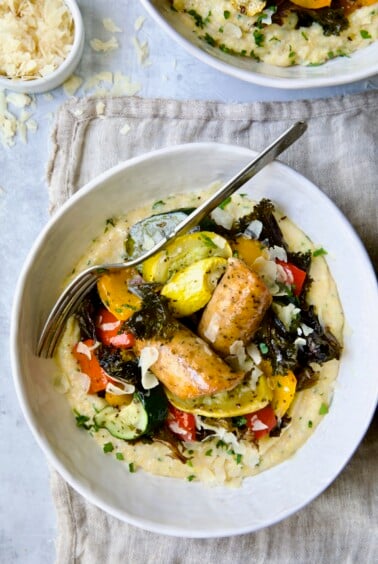 Chicken Sausage Sheet Pan and Polenta in white bowl with fork.