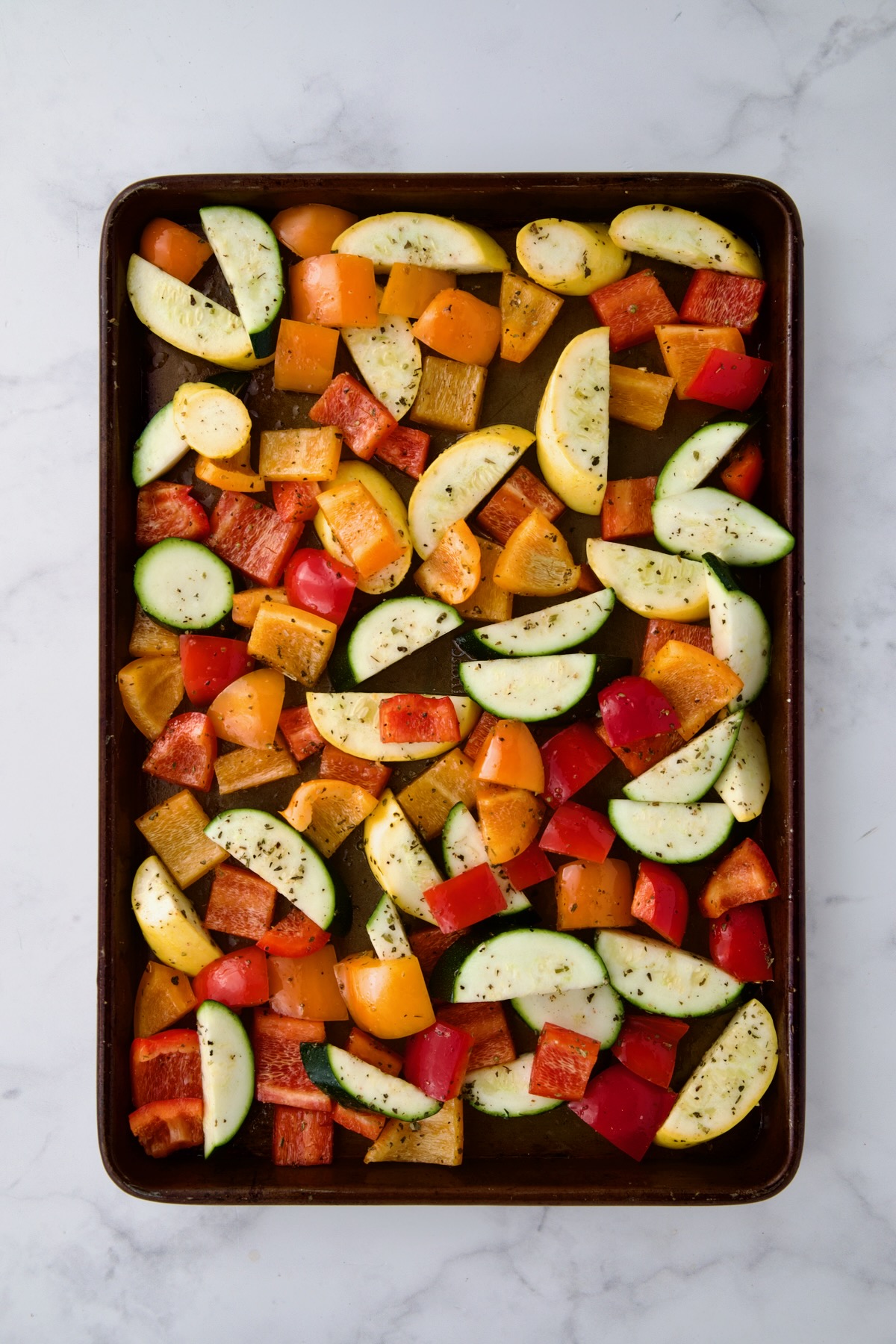 Uncooked vegetables on rimmed sheet pan.
