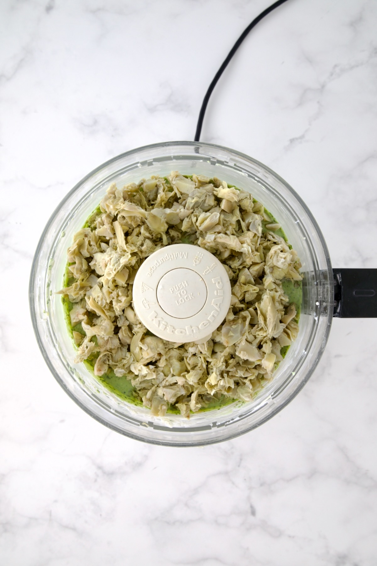 Chopped artichokes added to yogurt, cream cheese and spinach in food processor.