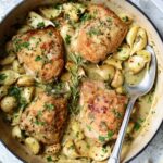 Finished 40 Clove Garlic Chicken in white enamel cast iron skillet.