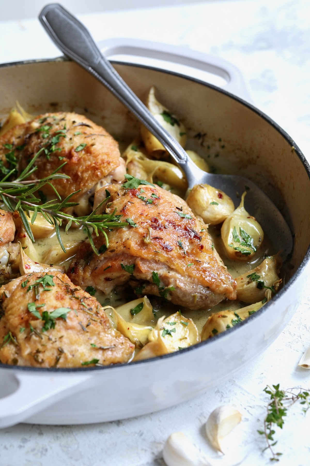 Finished 40 Clove Garlic Chicken in white enamel cast iron skillet.
