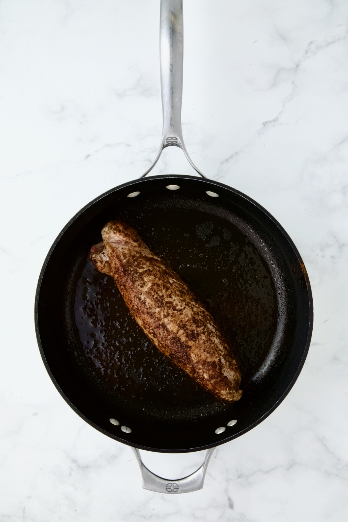 Seasoned and browned pork tenderloin in nonstick cast iron skillet.