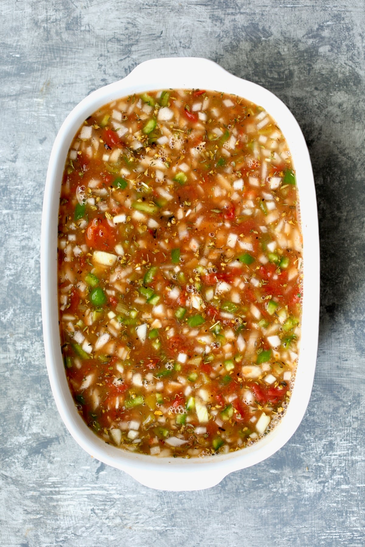 Ingredients for Southwestern Lentil and Brown Rice Bake in oval white baking dish before being baked,