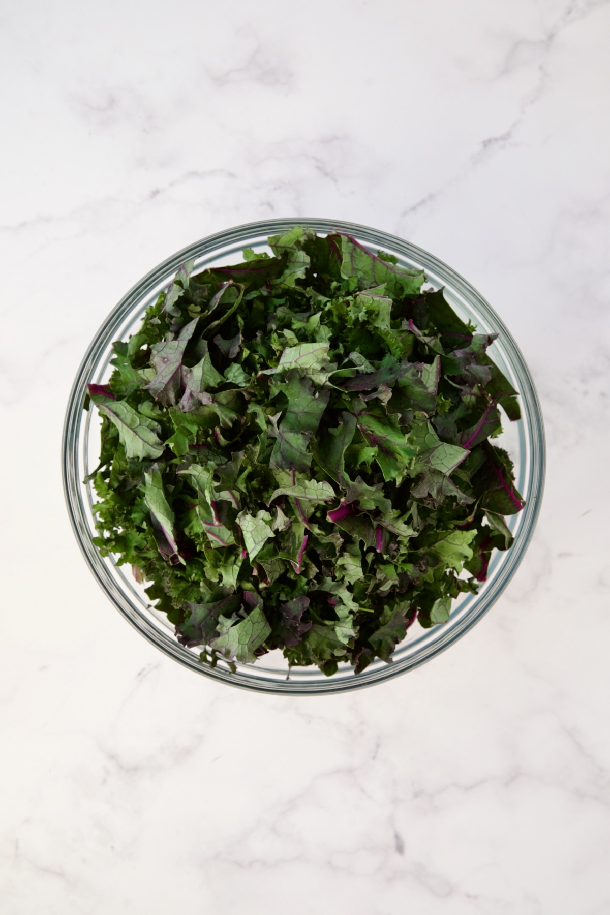Chopped red kale in glass bowl.