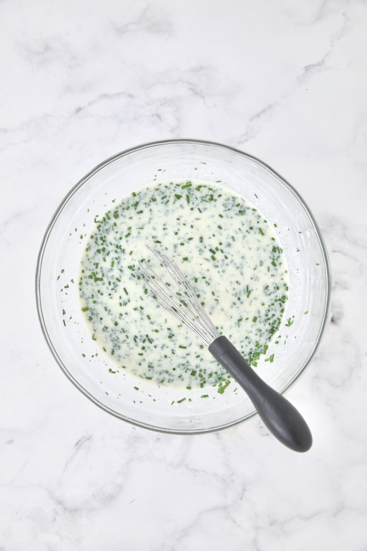 Wet ingredients for bread in glass bowl.