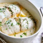 Two servings of Crab-Stuffed Flounder in oval baking dish.