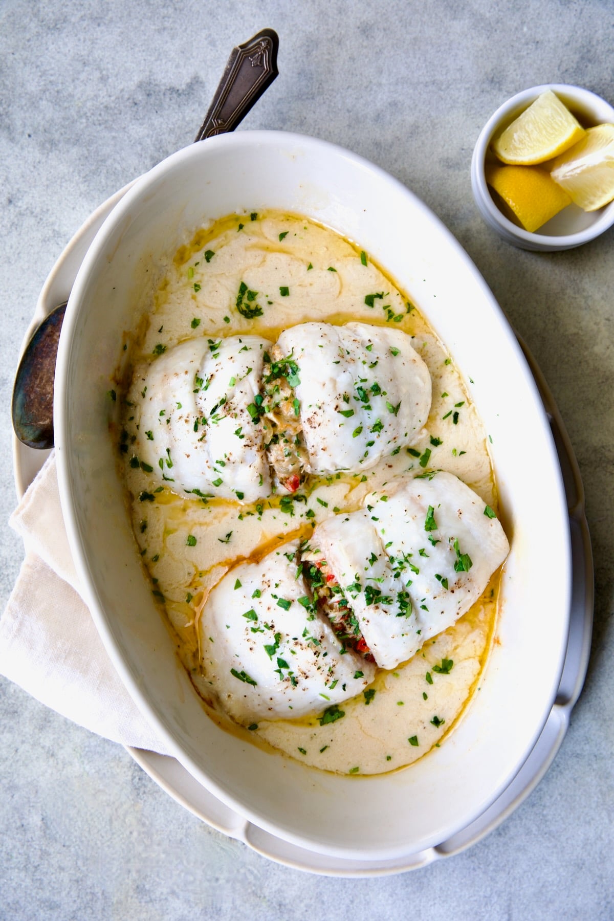 Two servings of Crab-Stuffed Flounder after being baked in oval baking dish.