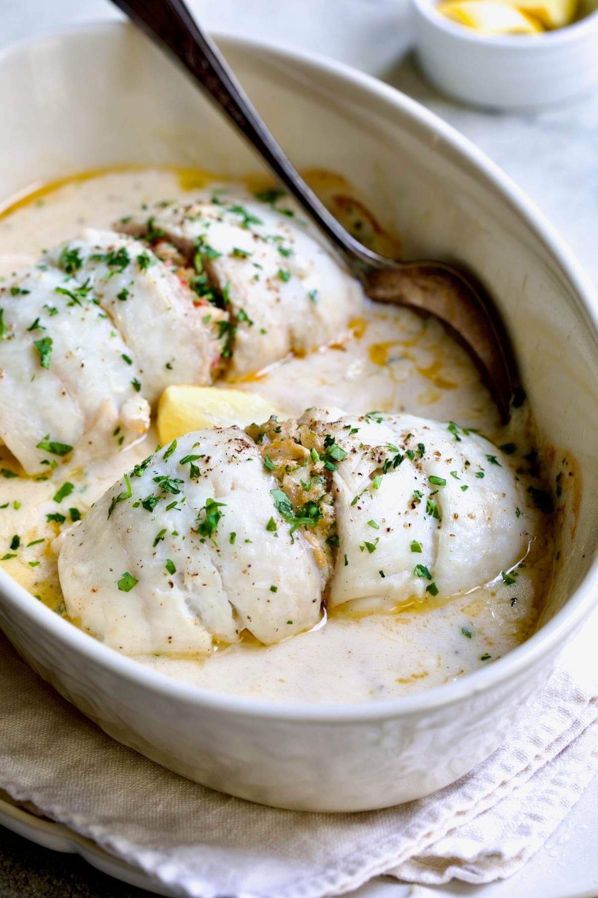 Two servings of Crab-Stuffed Flounder in oval baking dish after being baked.