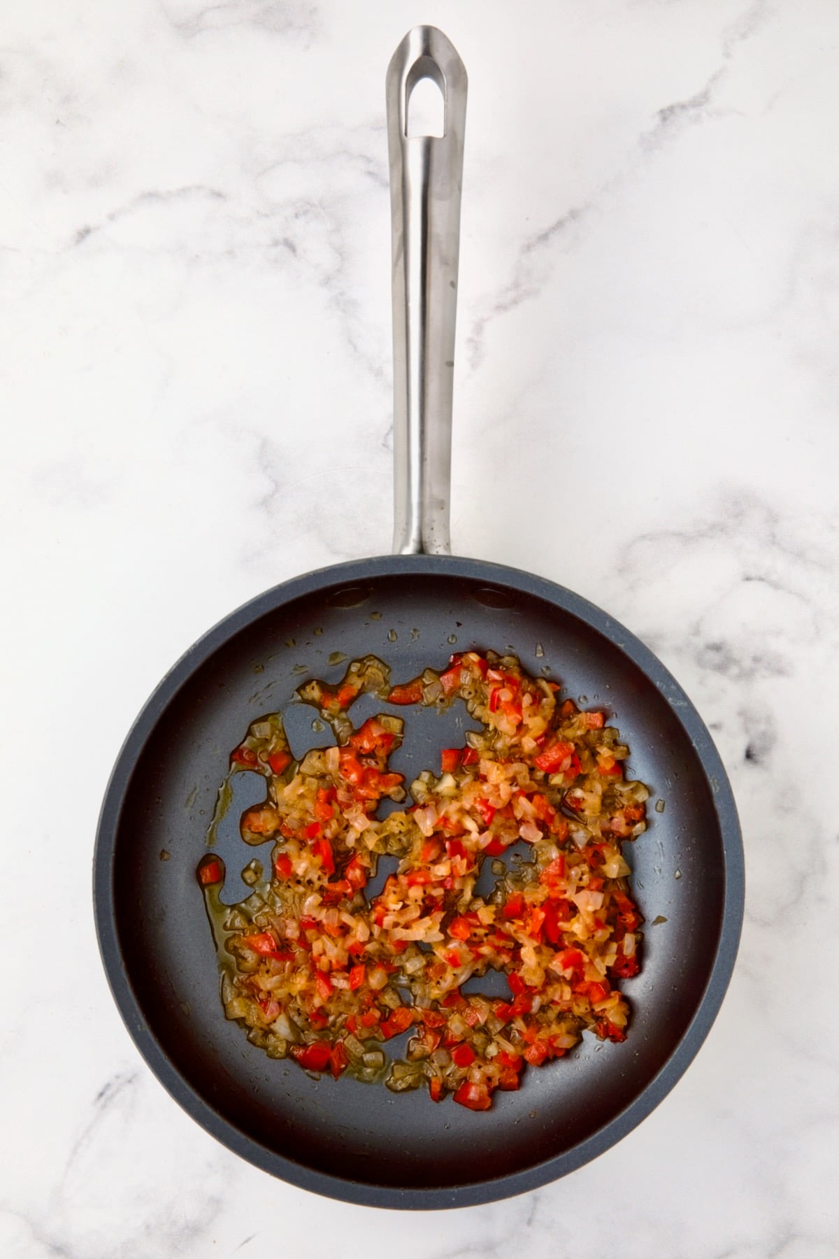 Cooked shallot and red bell pepper in nonstick skillet.