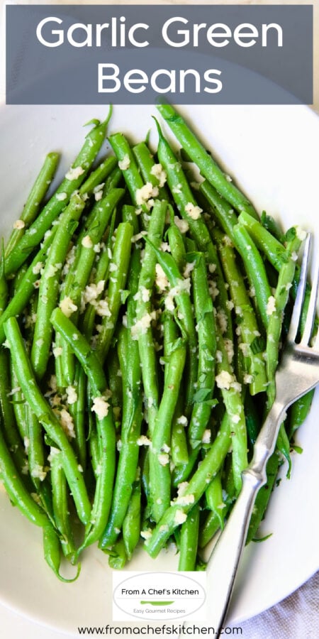 Pinterest graphic for Garlic Green Beans showing them in an oval white bowl with serving fork.