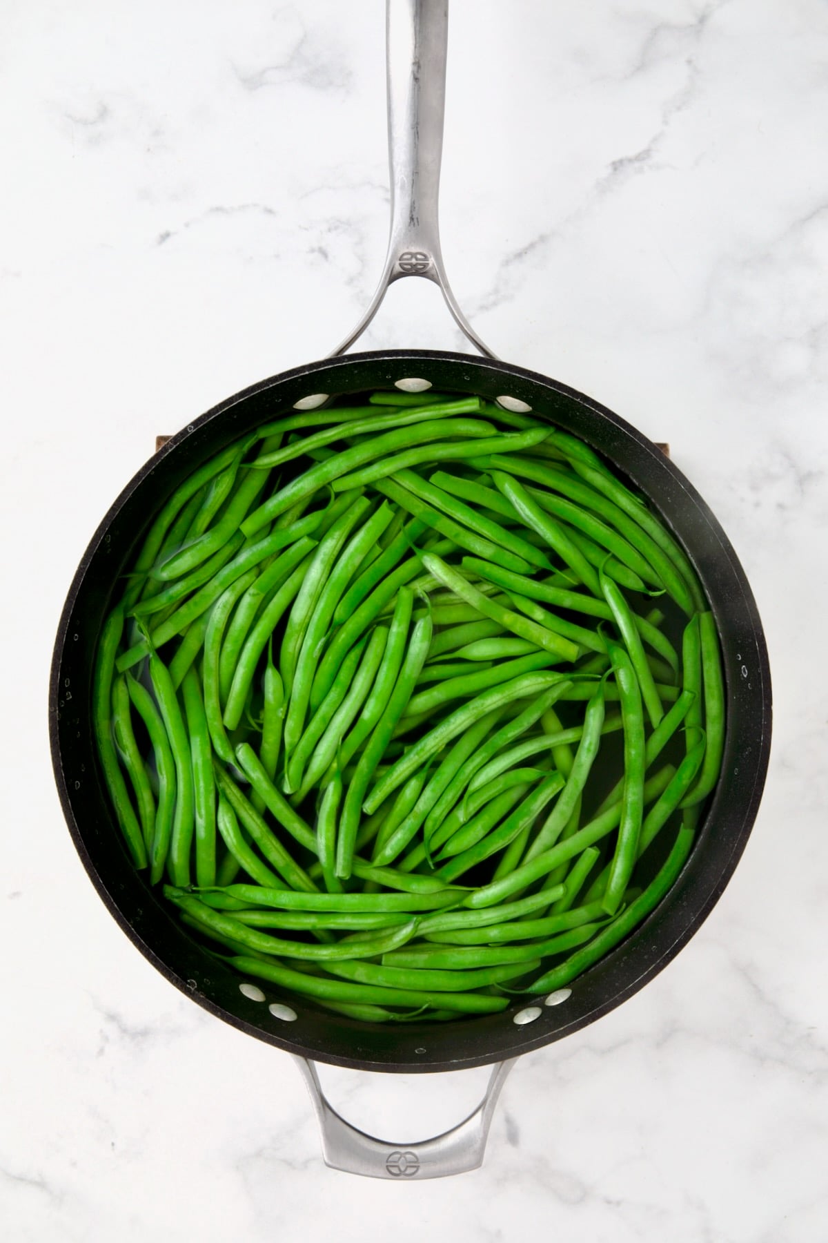 Green beans in water in skillet.